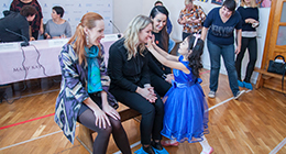 Mary Kay employees interacting with a child at a philanthropic event.