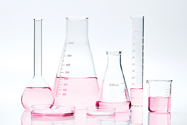 Recipiente de laboratorio lleno de líquido rosa para representar la investigación que hace Mary Kay. 