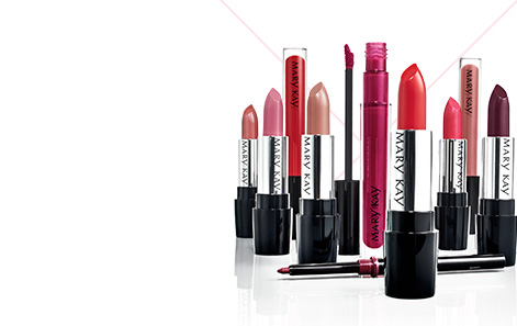 A group of red, pink and nude Mary Kay® lipsticks, lip glosses and lip liners photographed together with caps off to show their beautiful colors