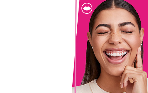 Una modelo sonriente luce productos de maquillaje Mary Kay® sobre un fondo rosa intenso.