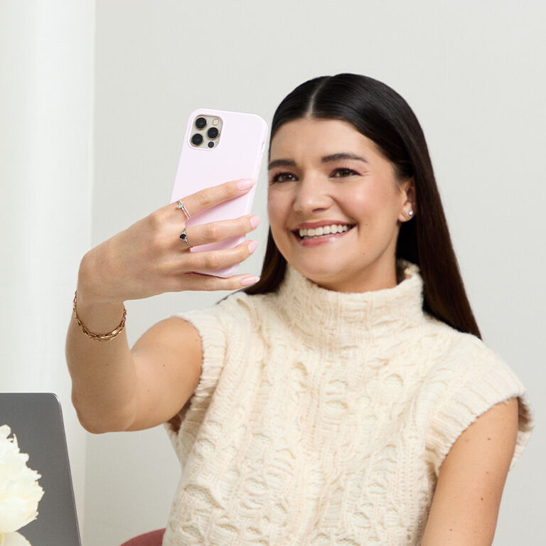 Woman holding a phone up to take a selfie