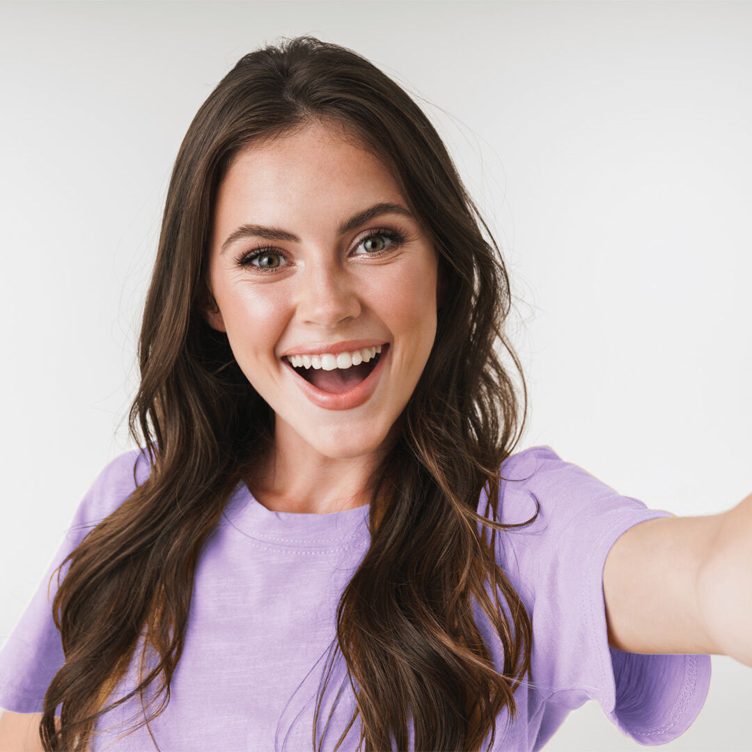 Mujer sonriendo tom&aacute;ndose un selfie frente a la c&aacute;mara