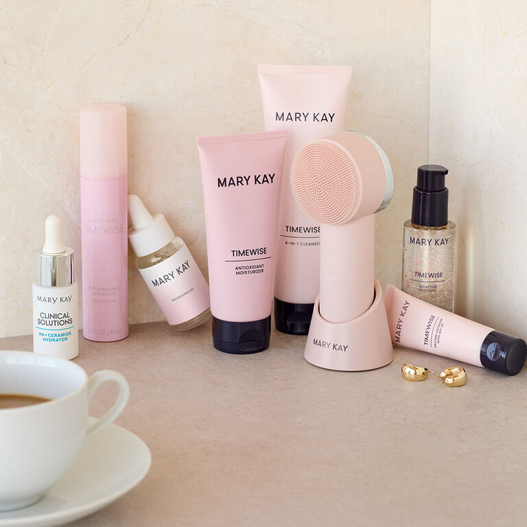 Assortment of Mary Kay skincare products, including TimeWise&reg;, Clinical Solutions&trade;, and a Mary Kay Skinvigorate&reg; Duo Facial Device on a stand, arranged on a bathroom counter