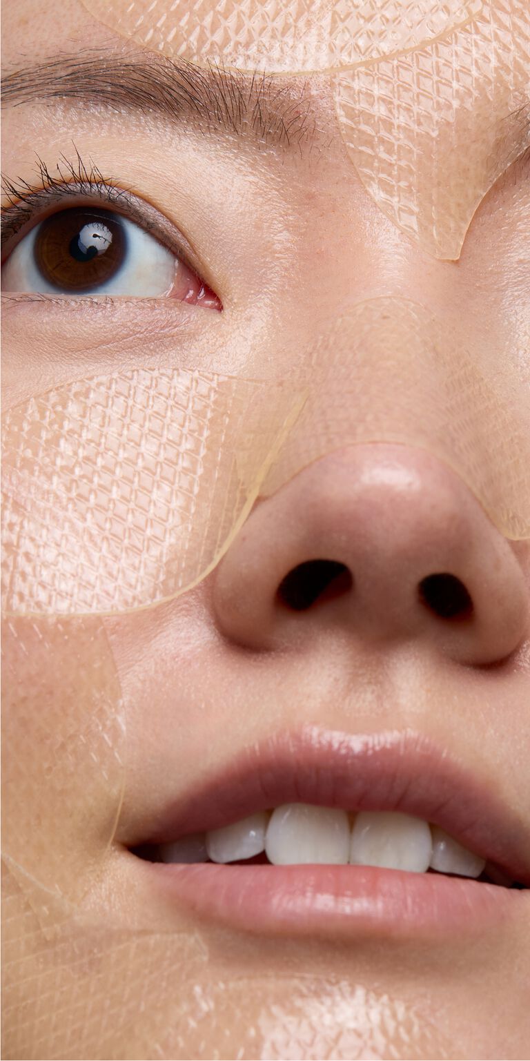 Close-up of woman wearing snail gel face patches