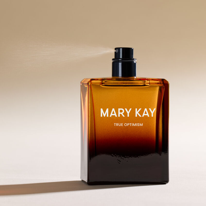 Mary Kay True Optimism Eau de Parfum rociando contra un fondo blanco