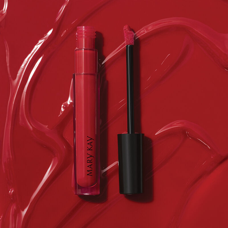 Open tube of Mary Kay Unlimited Lip Gloss in shade Iconic Red against accompanying shade rub.