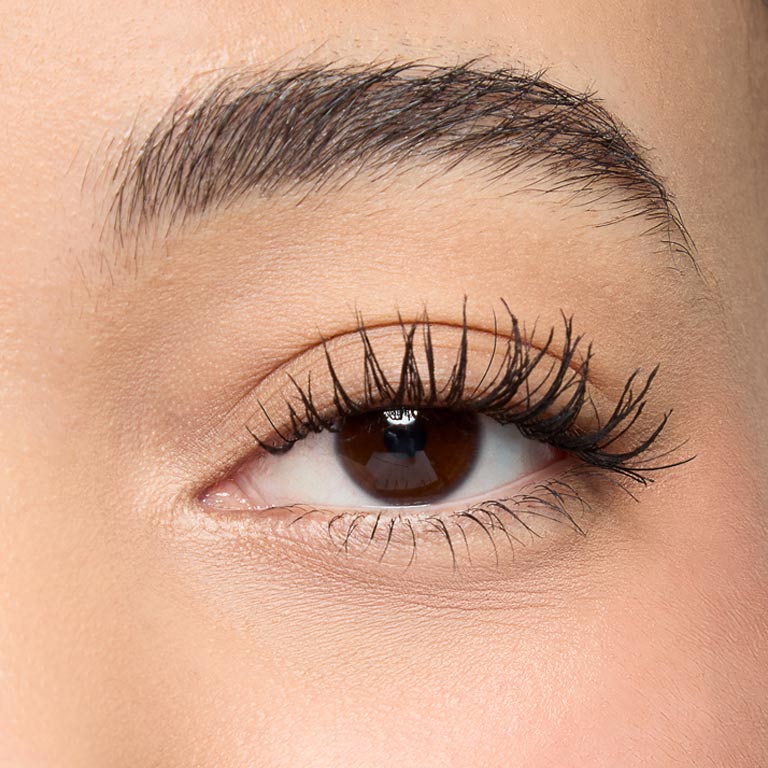 Foto en primer plano de una modelo con tono de piel intermedio mostrando sus pesta&ntilde;as despu&eacute;s de aplicar Mary Kay Great Heights Mascara