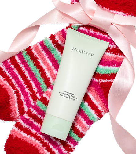 Mary Kay Mint Bliss energizing lotion tube displayed on red, pink, and mint striped fuzzy socks with a pale pink ribbon wrapped around the product.