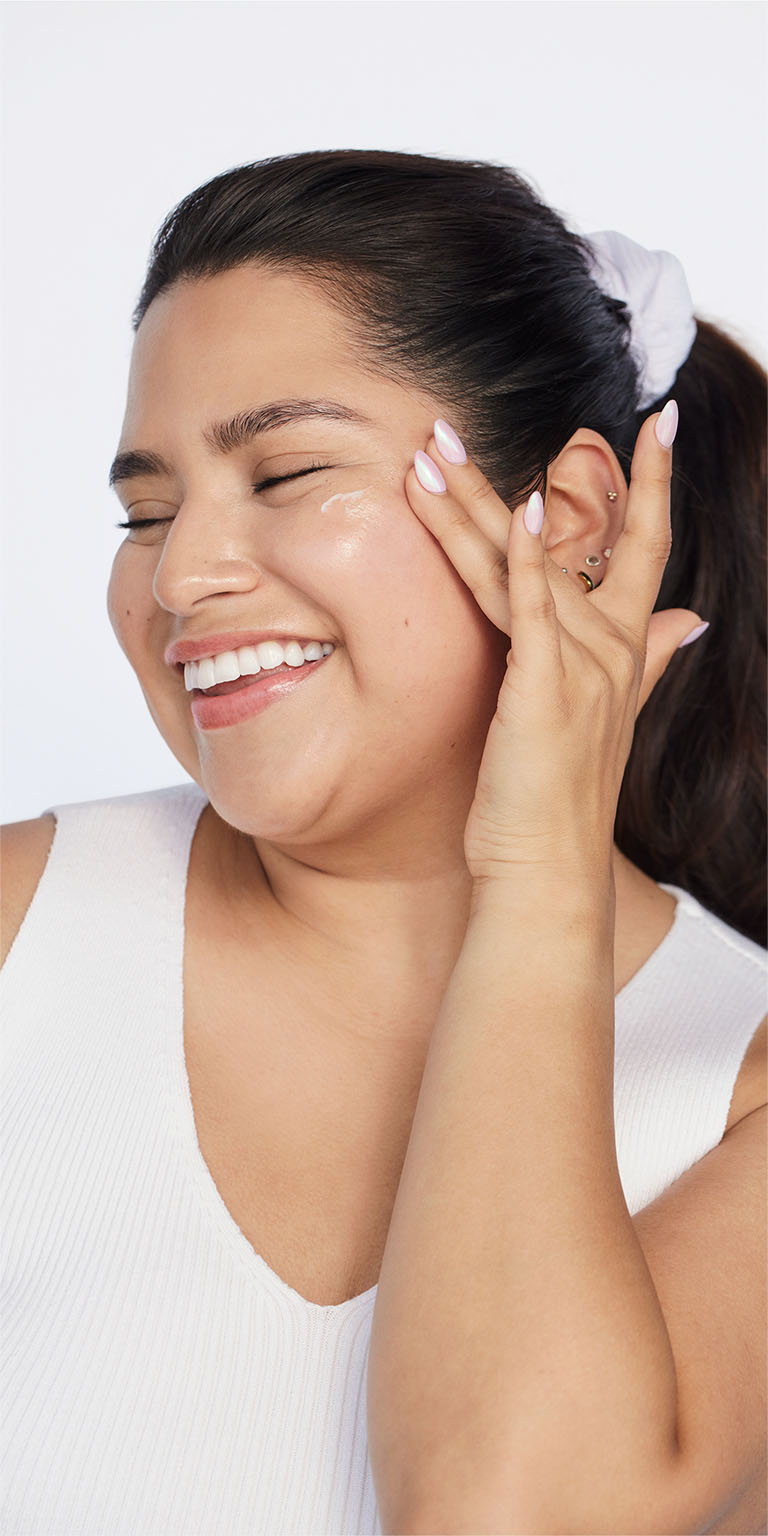 Mujer aplicando el Mary Kay Mineral Facial Sunscreen Broad Spectrum SPF 30 a un lado de su mejilla