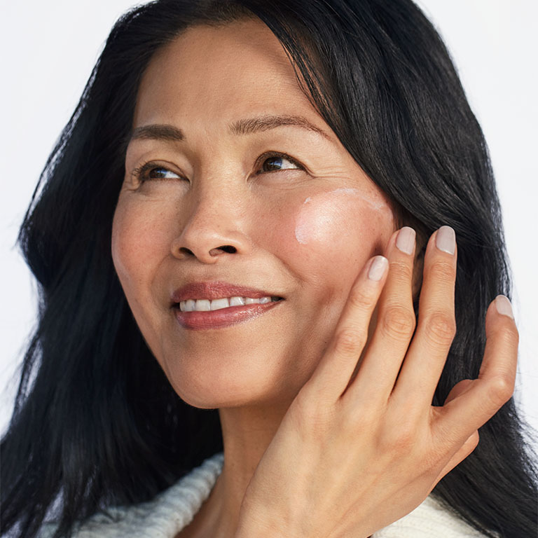 Modelo aplicando el Mary Kay Sunscreen Broad Spectrum SPF 50 en su mejilla