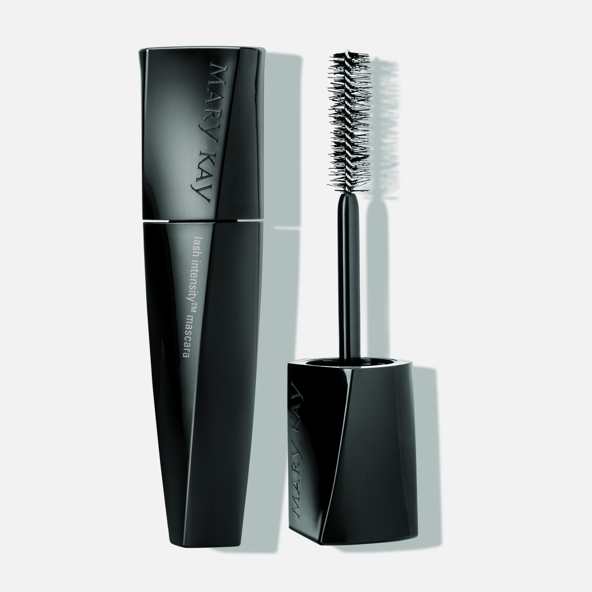 Angular black bottle of Mary Kay Lash Intensity&reg; Mascara and uncapped mascara wand on plain background